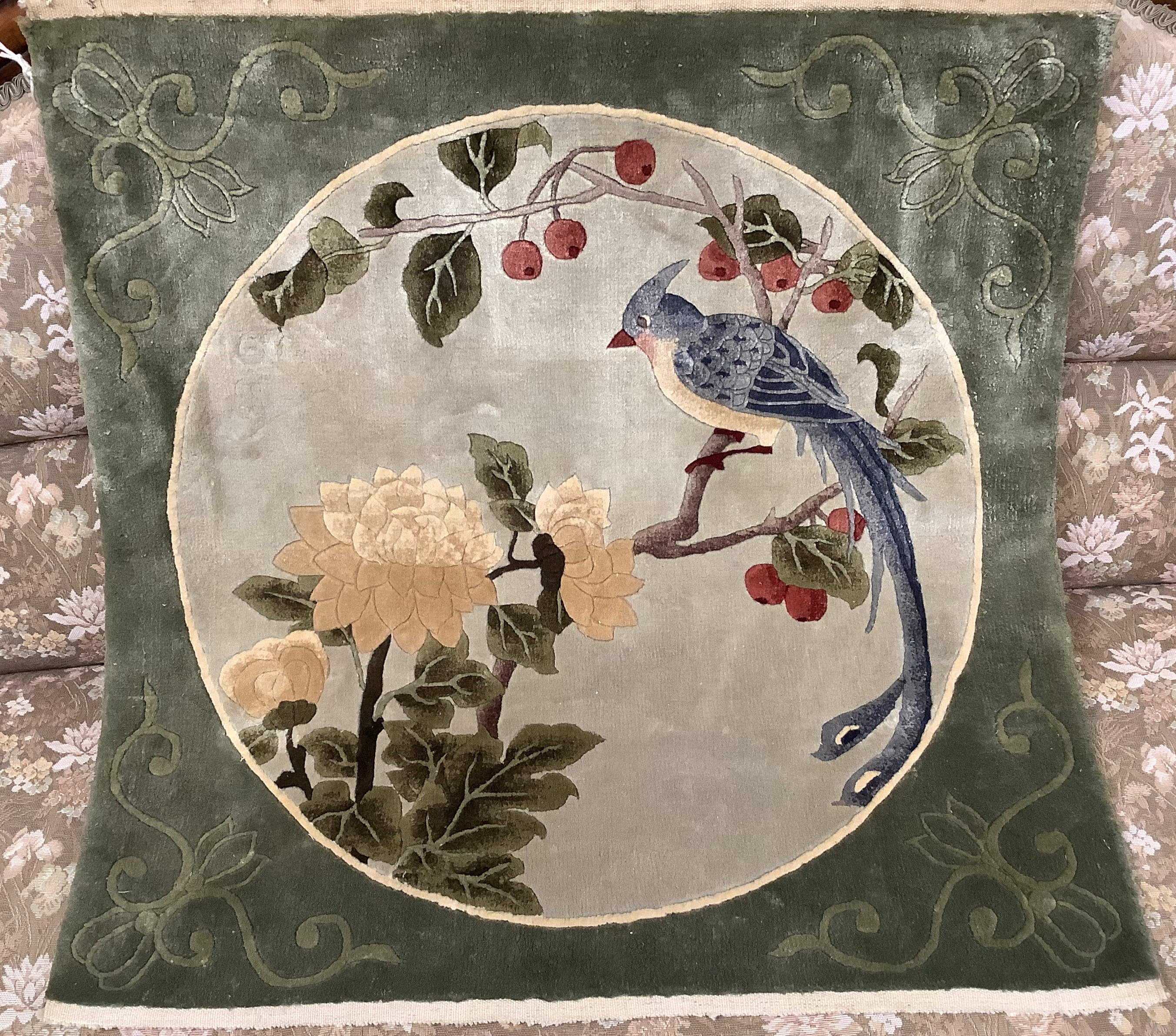 A Chinese washed and embossed panel depicting birds amongst prunus and cherries